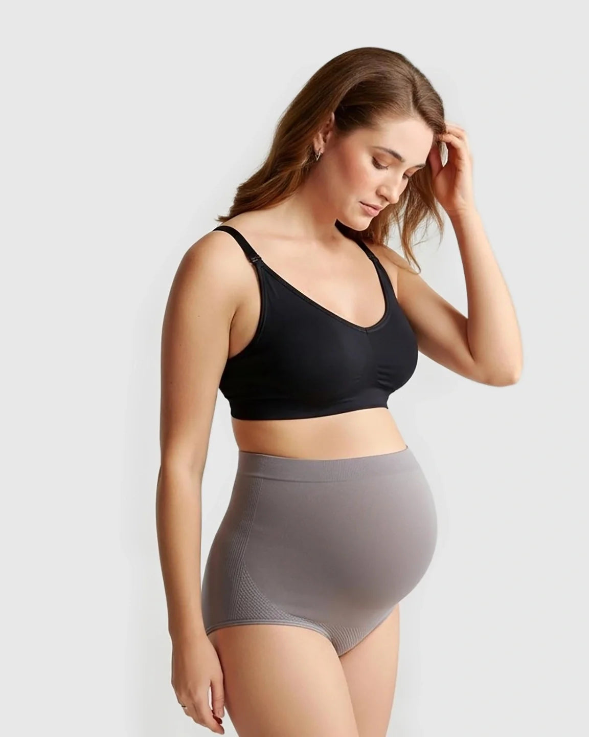 Pregnant woman in gray seamless high-waist maternity panties and a black bra.