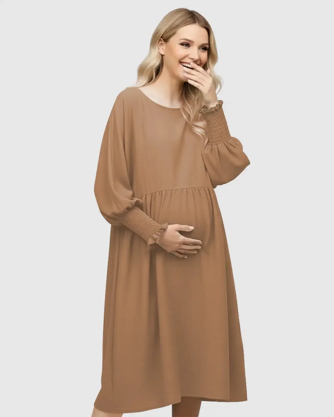 Smiling pregnant woman in a brown flowy smocked sleeve casual dress with a round neckline.