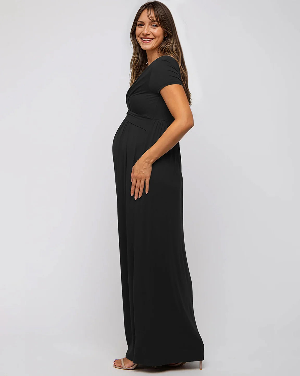 Smiling pregnant woman in a black Twist Front Draped Maternity Nursing Maxi Dress.