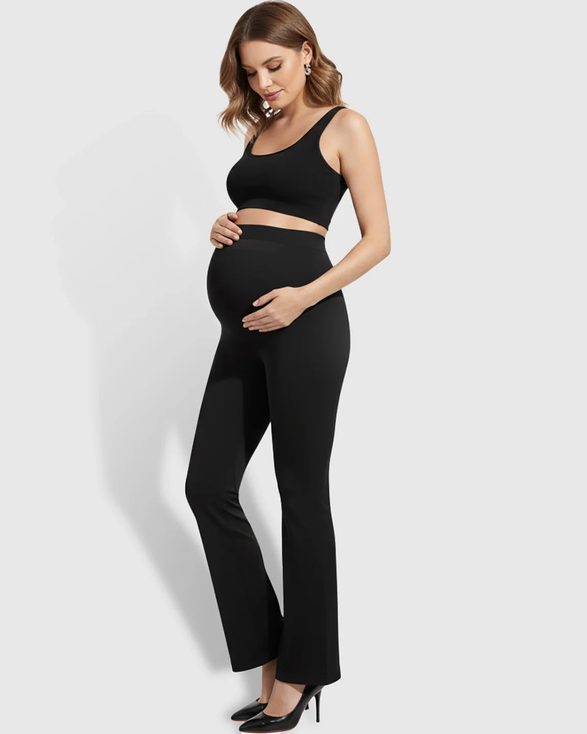 Pregnant woman in black Bump Society Over-Belly Bootcut Maternity Pants and matching crop top.