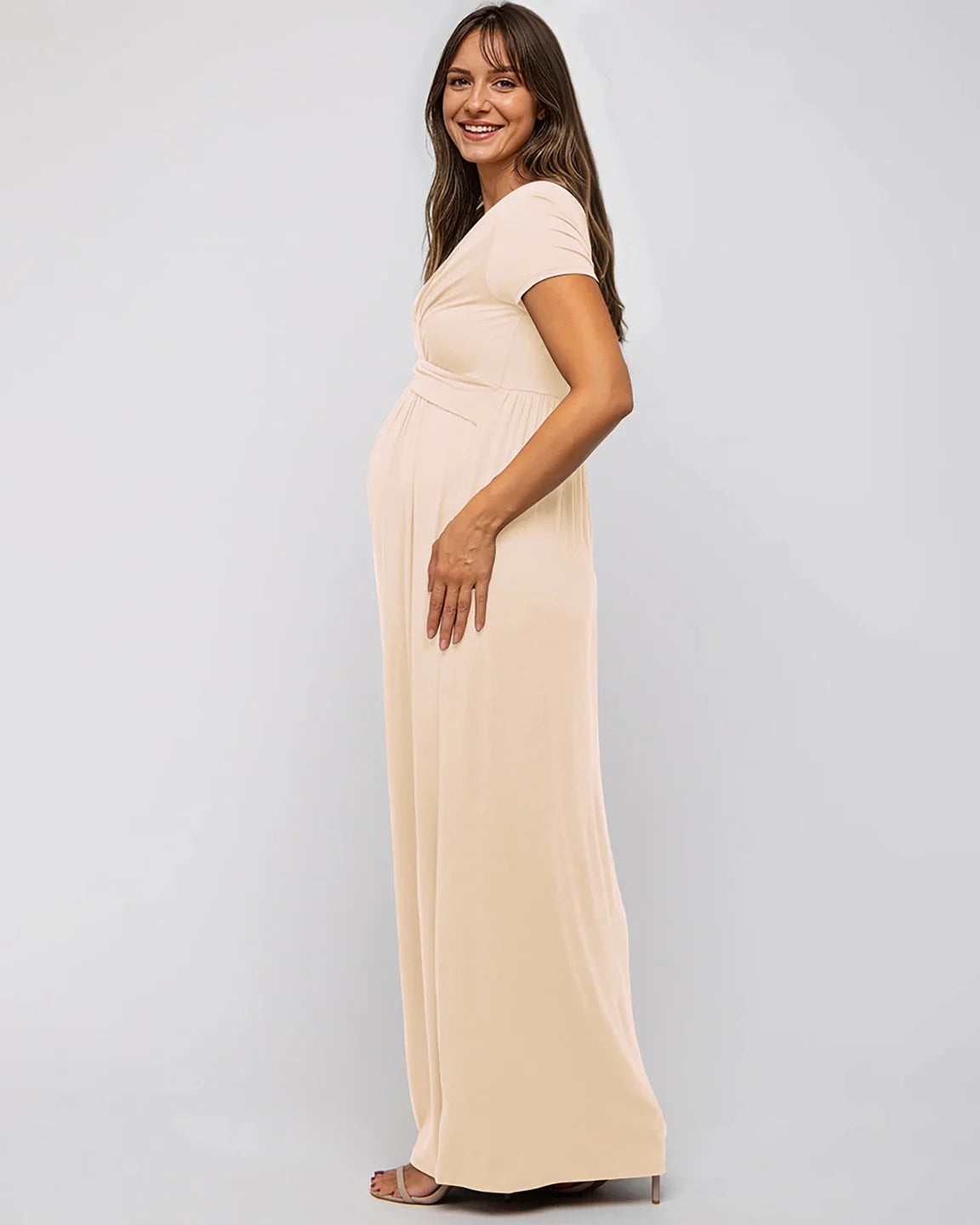 Smiling pregnant woman in a peach Twist Front Draped Maternity Nursing Maxi Dress.