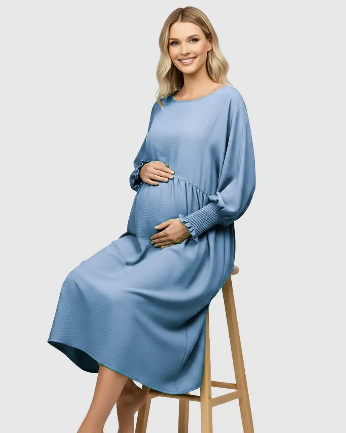 Smiling pregnant woman in a blue flowy smocked sleeve casual dress with a drawstring waist.