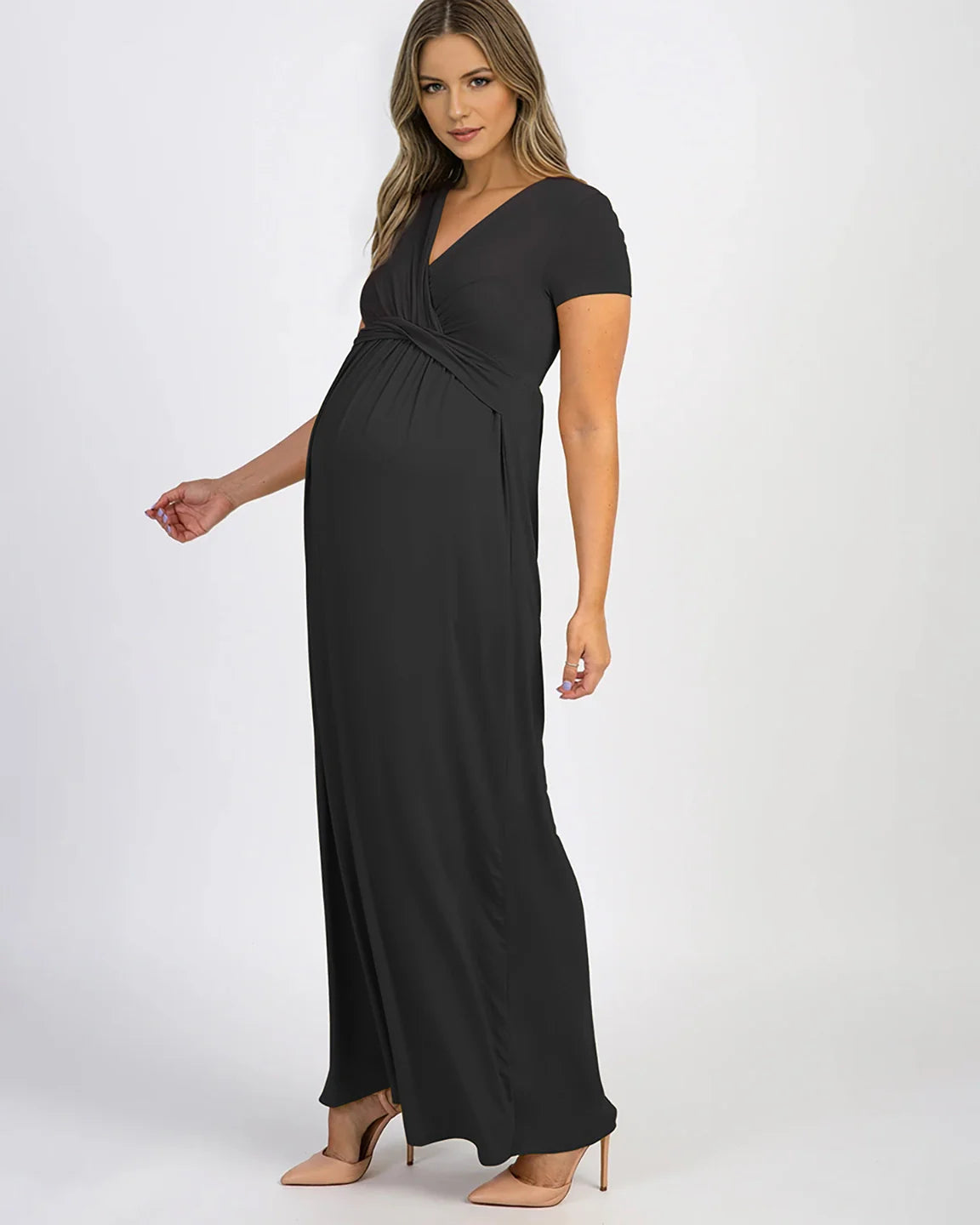 Woman in a black, short-sleeve, twist-front draped maternity nursing maxi dress with a V-neck.