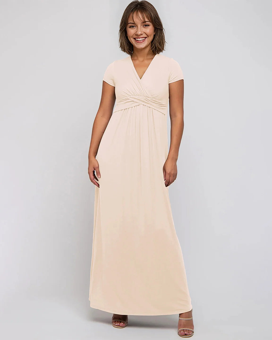 Smiling woman in a light peach Twist Front Draped Maternity Nursing Maxi Dress with short sleeves.