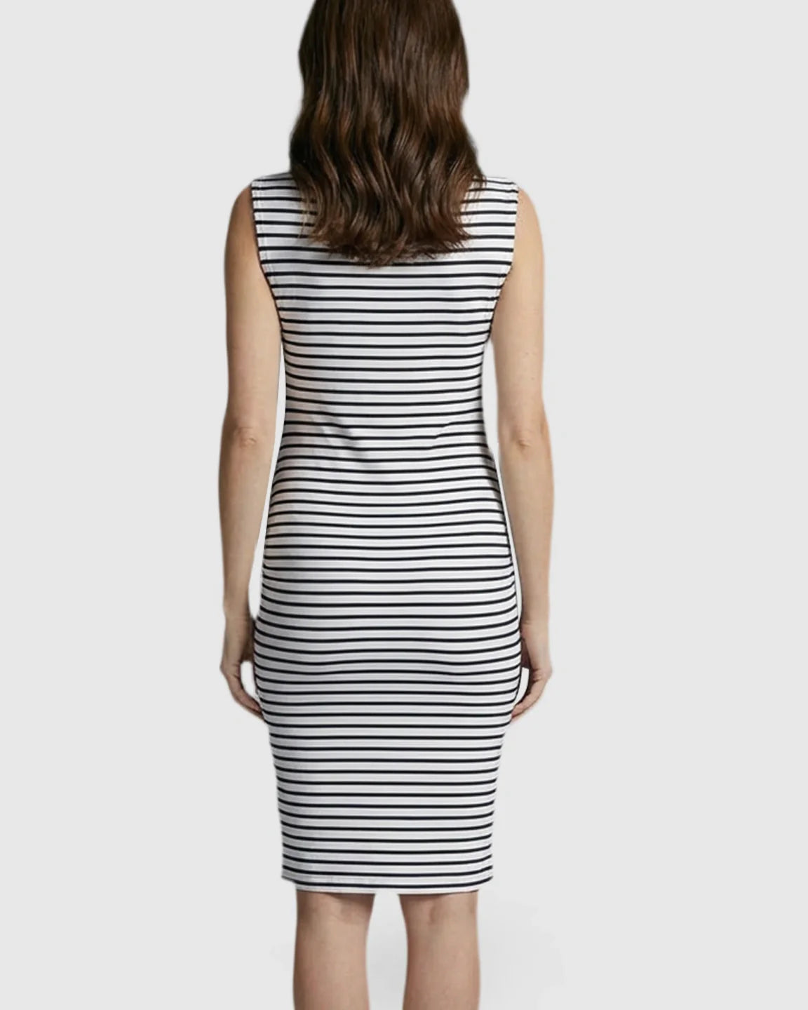 Back view of a woman in a black and white striped sleeveless bodycon maternity midi dress.