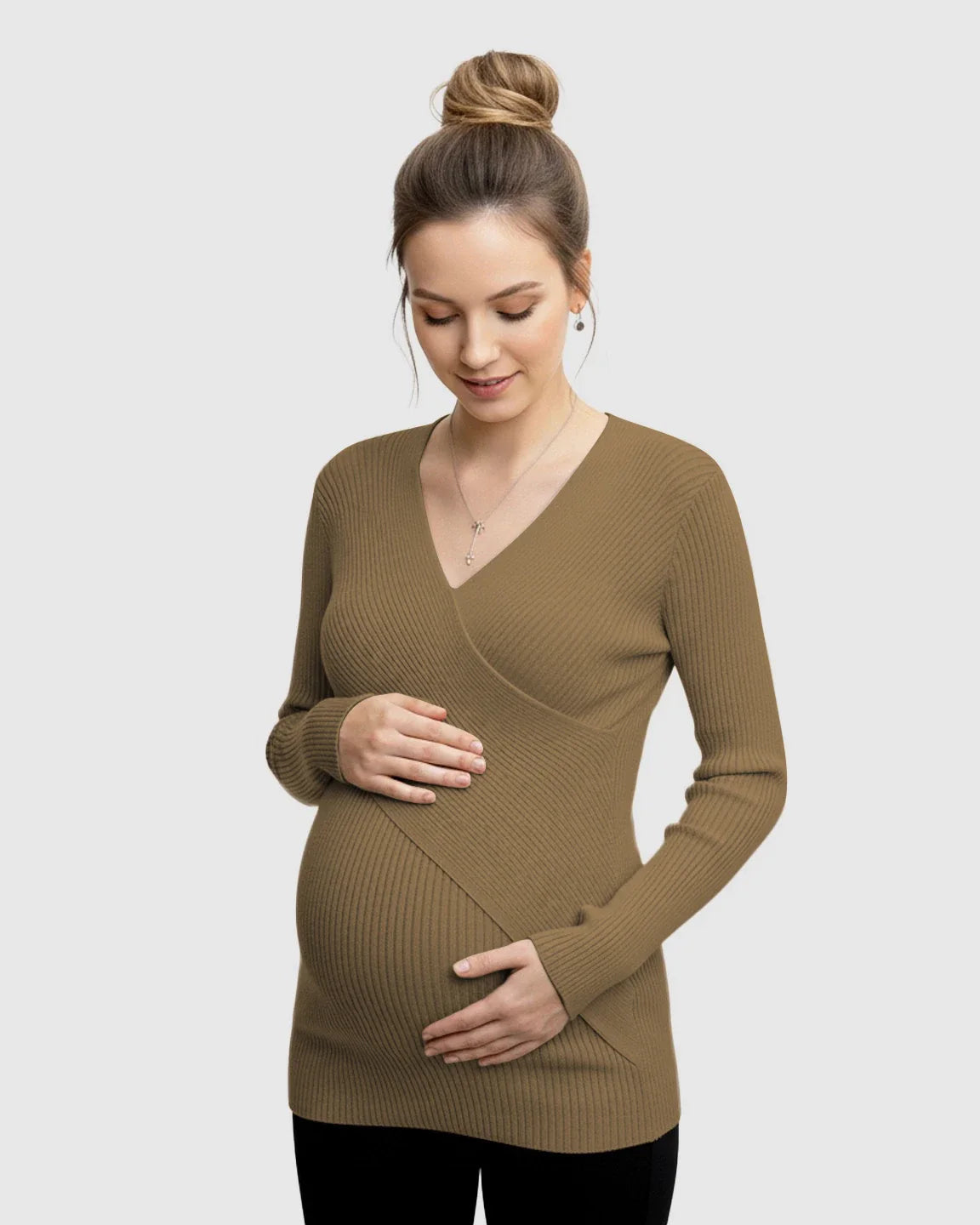Maternity model in a brown faux-wrap ribbed knit long-sleeve top, holding her bump.