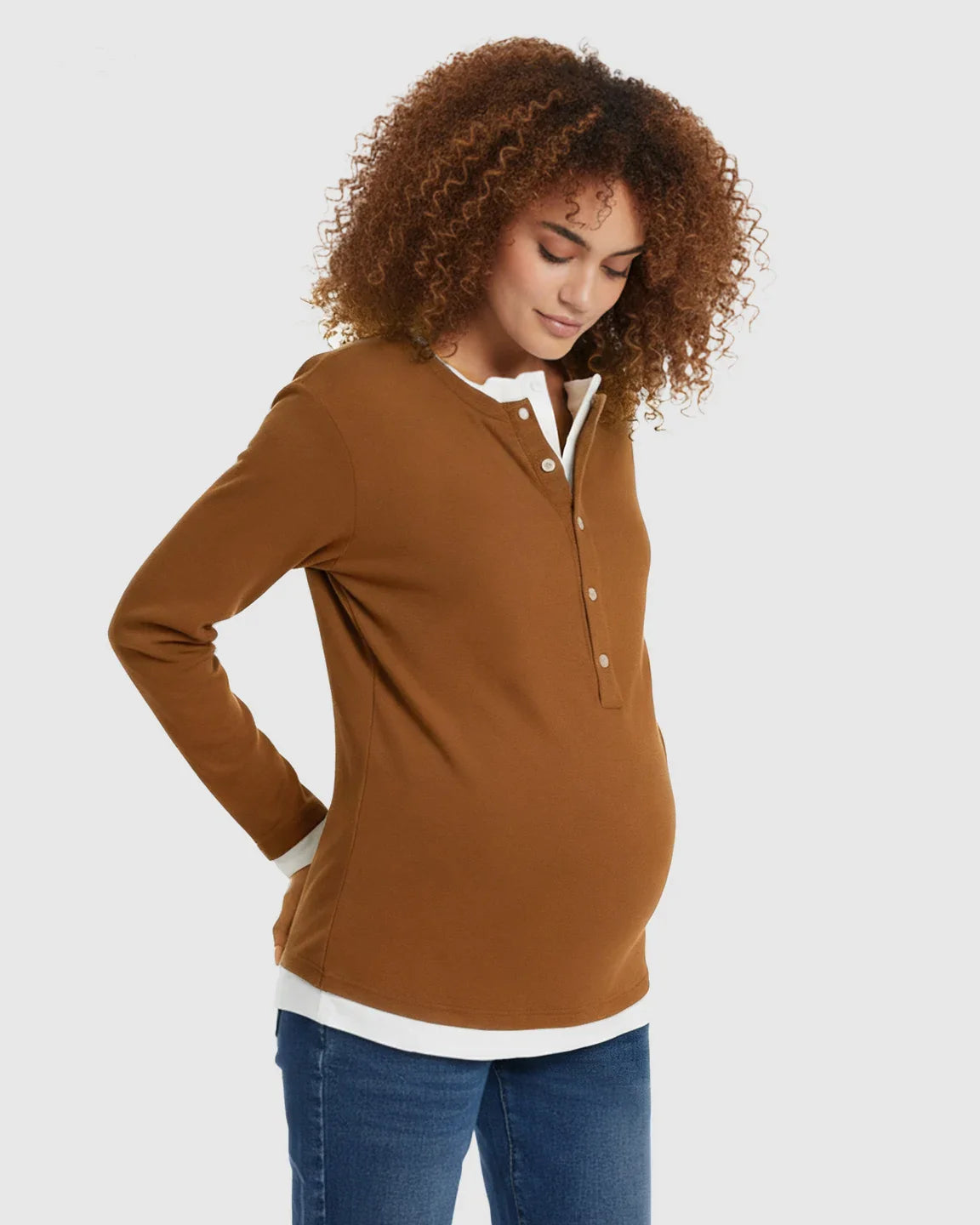 Pregnant woman in a brown long-sleeve button-front henley maternity and nursing top with a white underlayer.