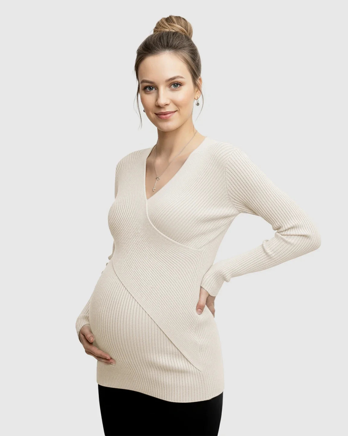 Smiling pregnant woman in a cream faux-wrap ribbed maternity top, long sleeves, V-neck.