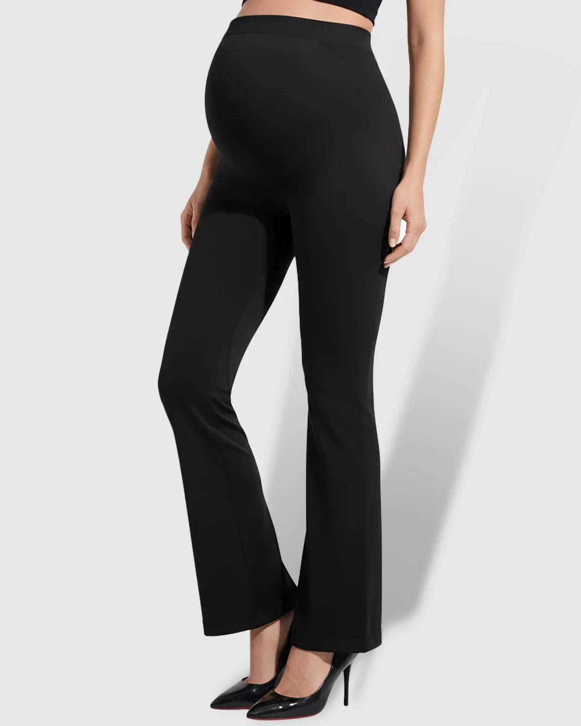 Black over-belly bootcut maternity pants with a soft flare, made from stretchy fabric.