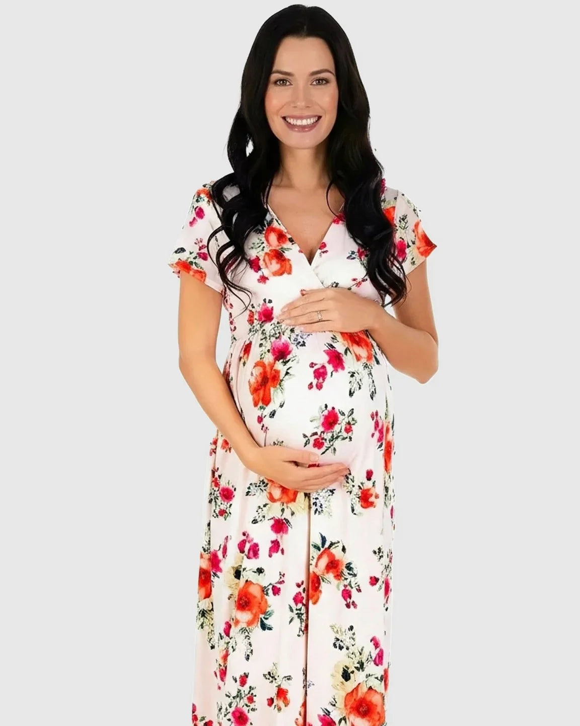 Smiling pregnant woman in a white floral V-neck short sleeve maternity maxi dress.