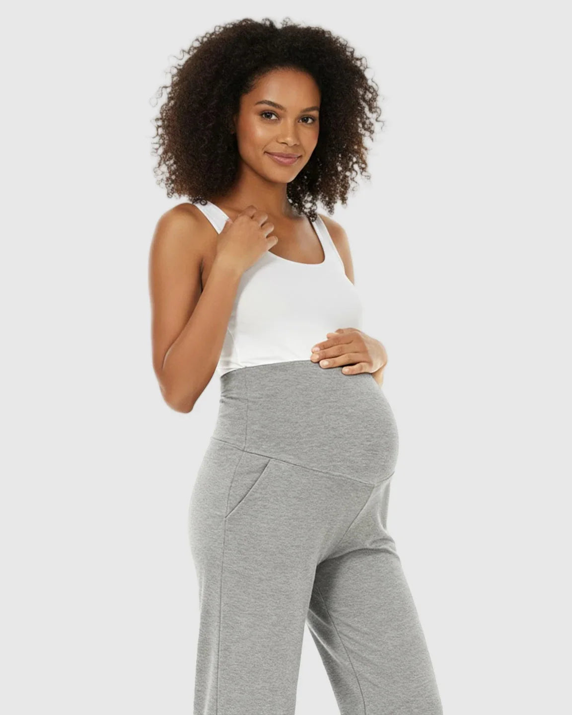 Pregnant woman in gray wide-leg maternity lounge pants with a foldable waistband and side pockets.