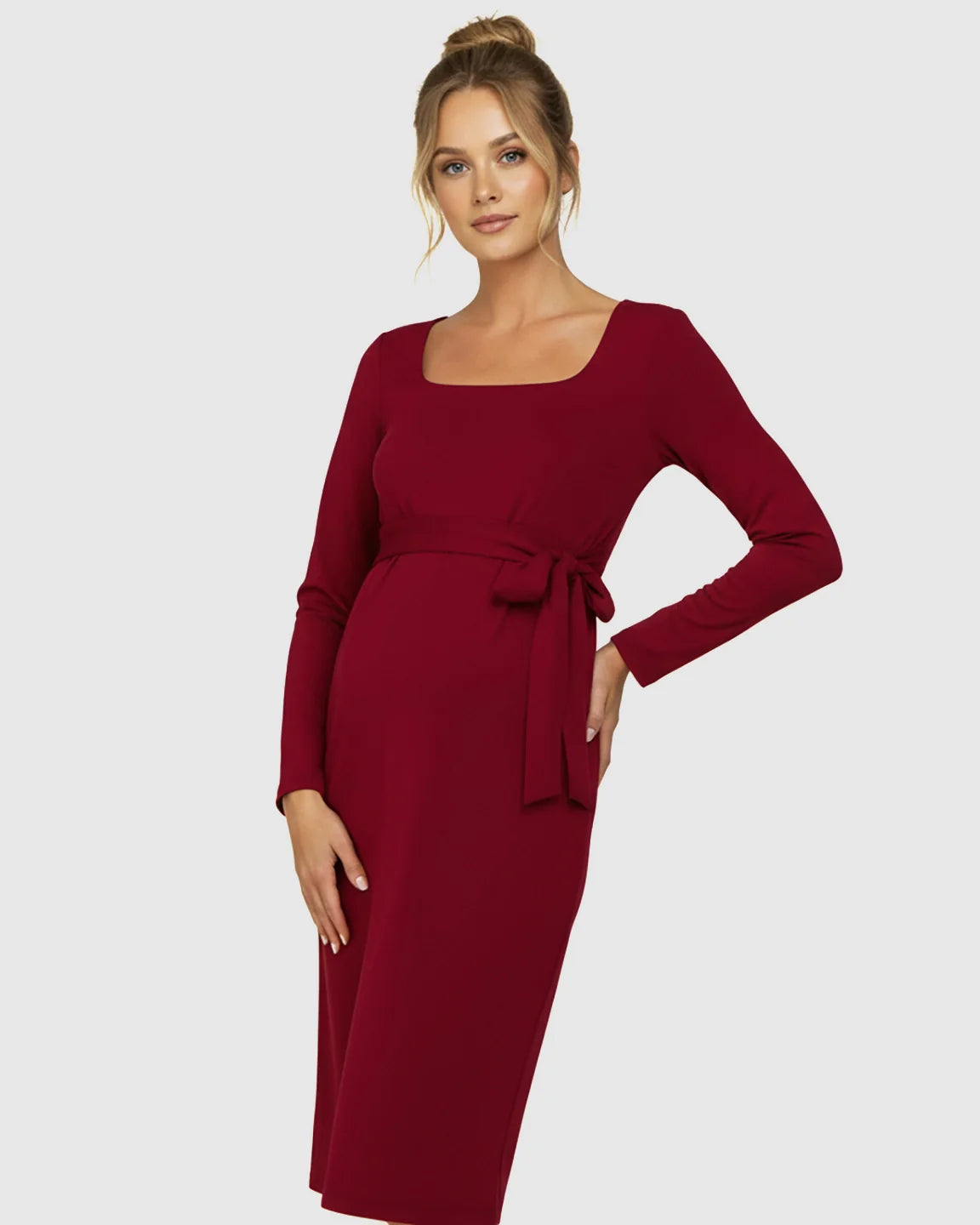 Pregnant woman in a red square neck, long-sleeve bodycon maternity midi dress with a side-tie.