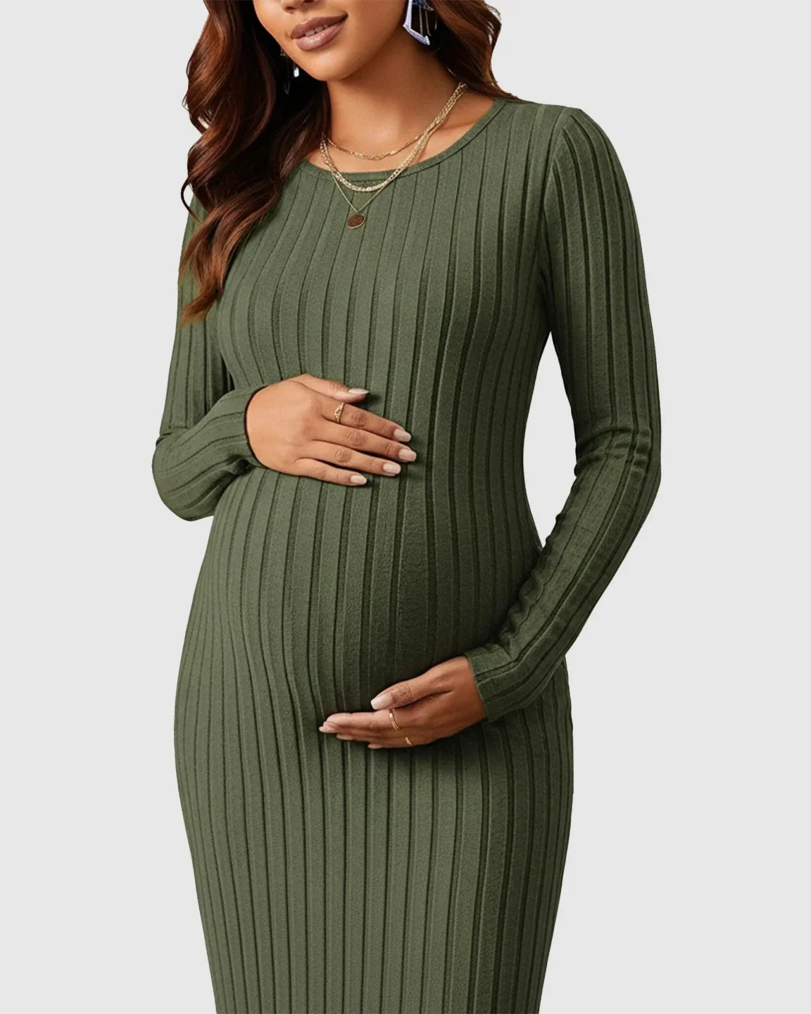 Maternity model in a long-sleeve olive green ribbed knit maxi dress, cradling her baby bump.
