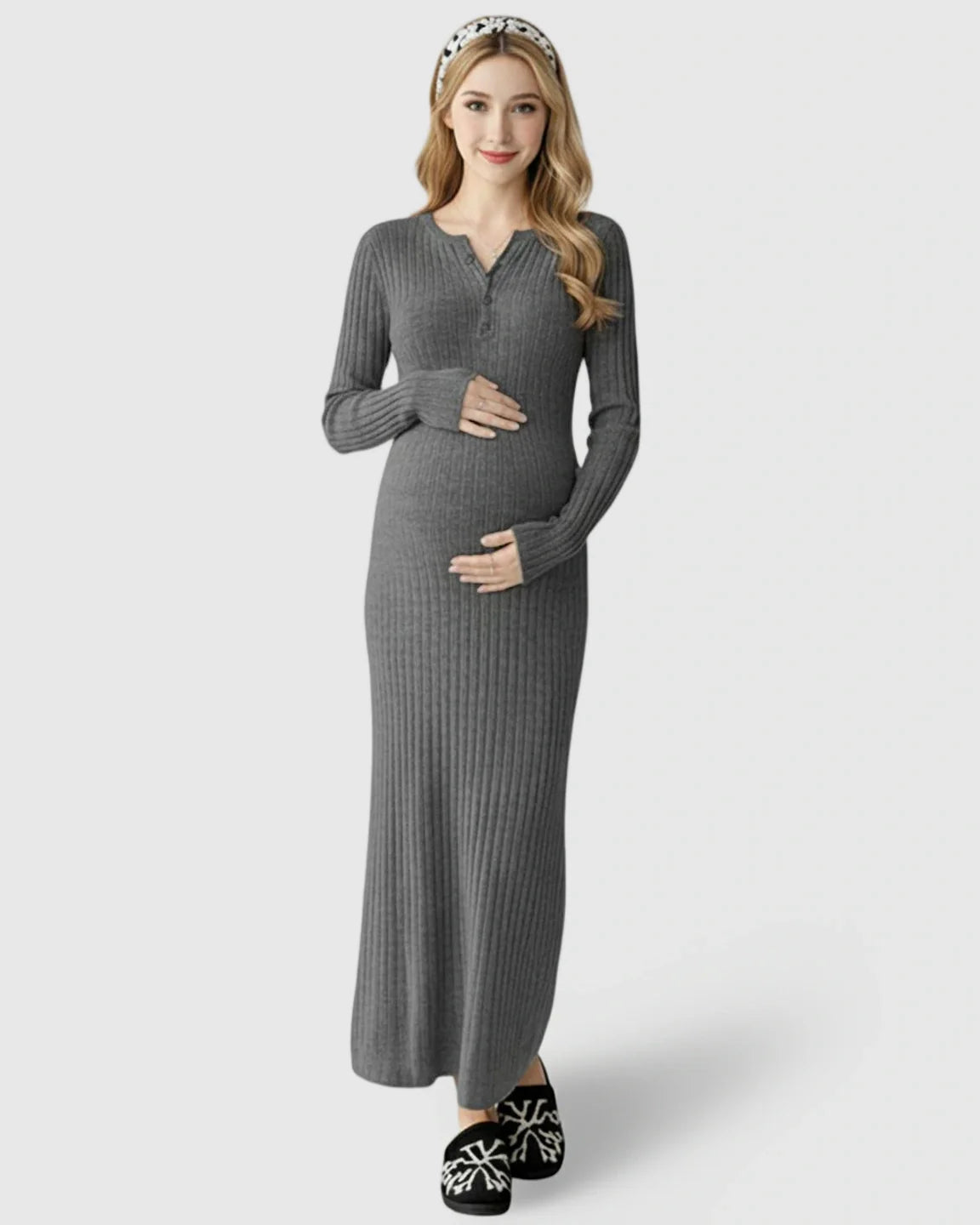 Smiling pregnant woman in a gray ribbed knit A-line long sleeve maternity maxi dress, hands on bump.