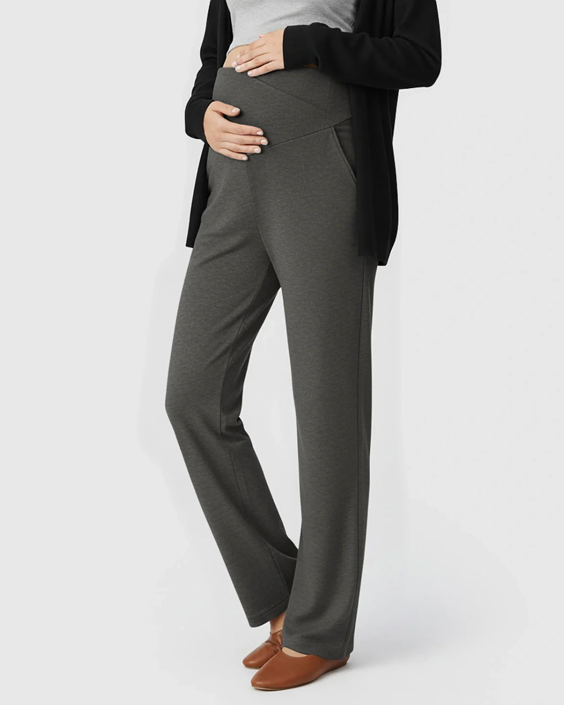 Pregnant woman wearing charcoal gray wide-leg maternity lounge pants with a crossover waist and side pockets.