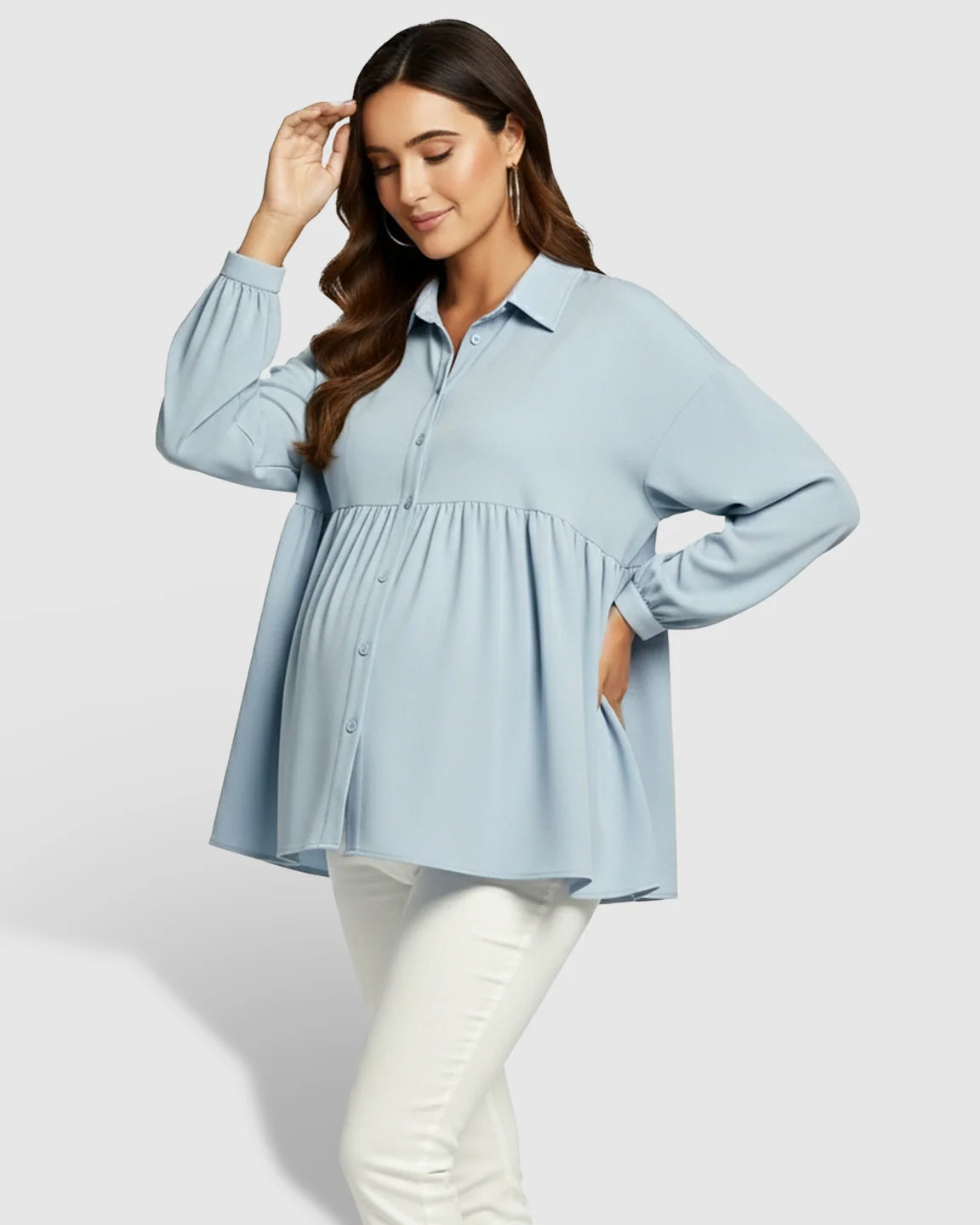 Maternity model in a light blue chiffon lapel long sleeve babydoll shirt, button-down front, and white pants.