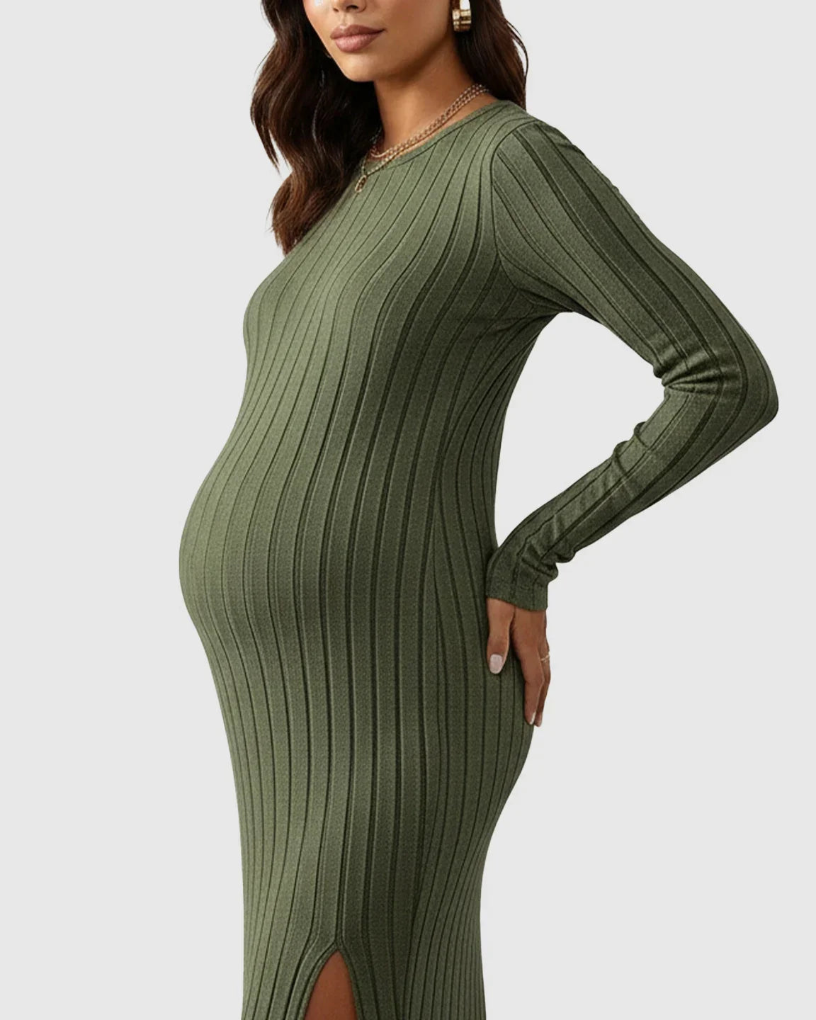 Pregnant woman in an olive green ribbed knit long-sleeve maternity maxi dress with a side slit.