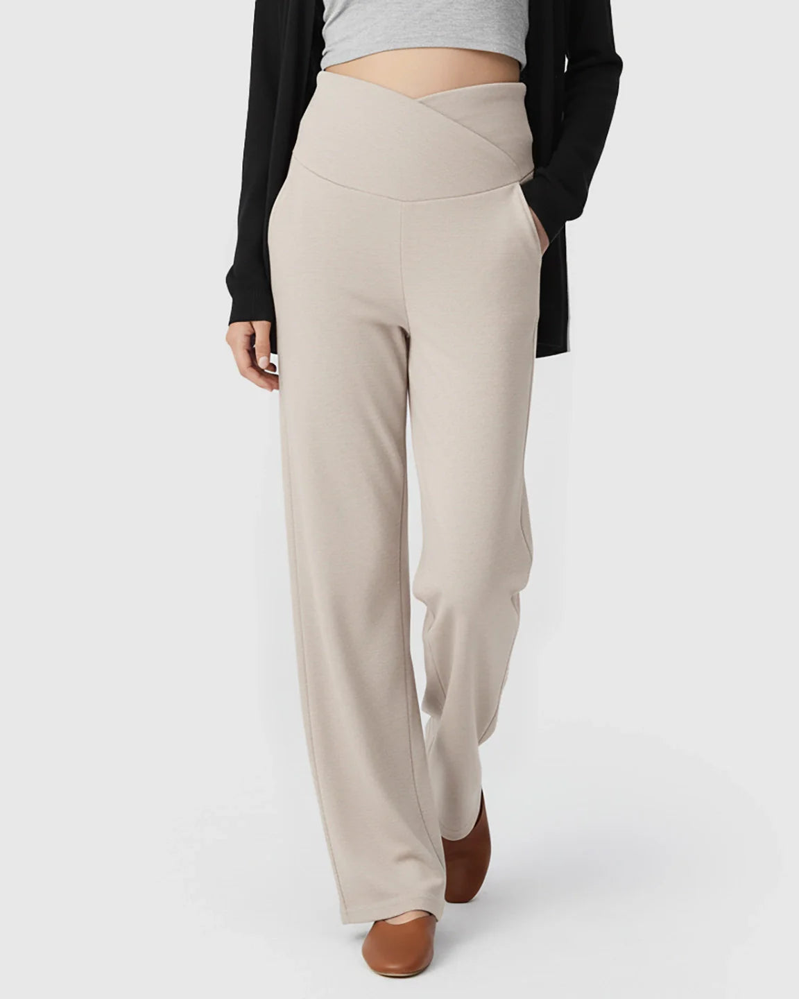 Beige wide-leg maternity lounge pants with a crossover waist, deep side pockets, and a relaxed fit.