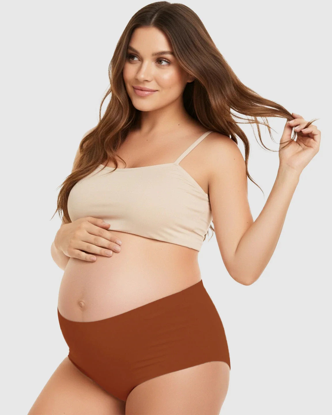 Smiling pregnant woman in seamless high-waist support maternity underwear in a warm brown color.