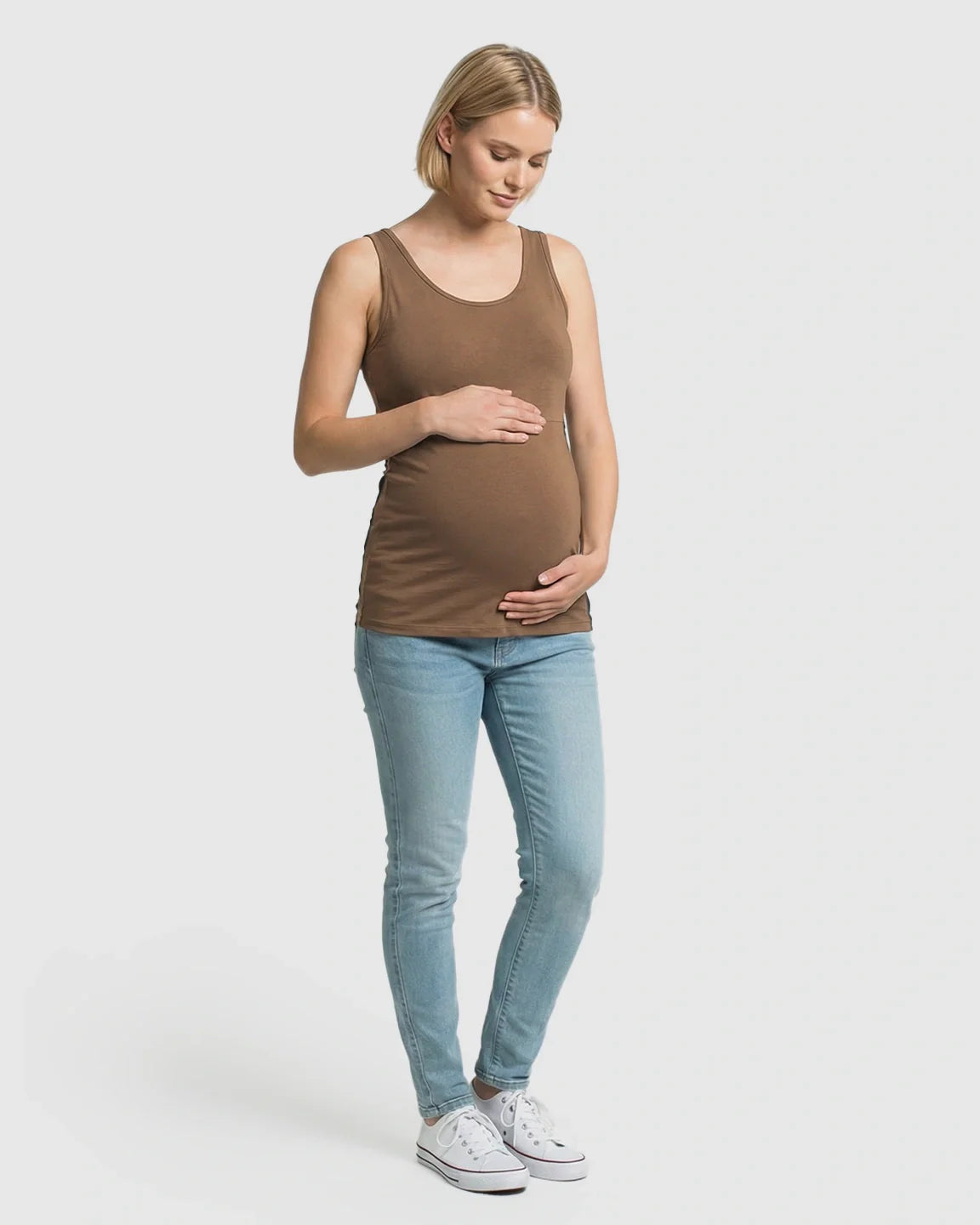 Pregnant woman in a brown stretch nursing-access maternity tank top and light wash jeans.