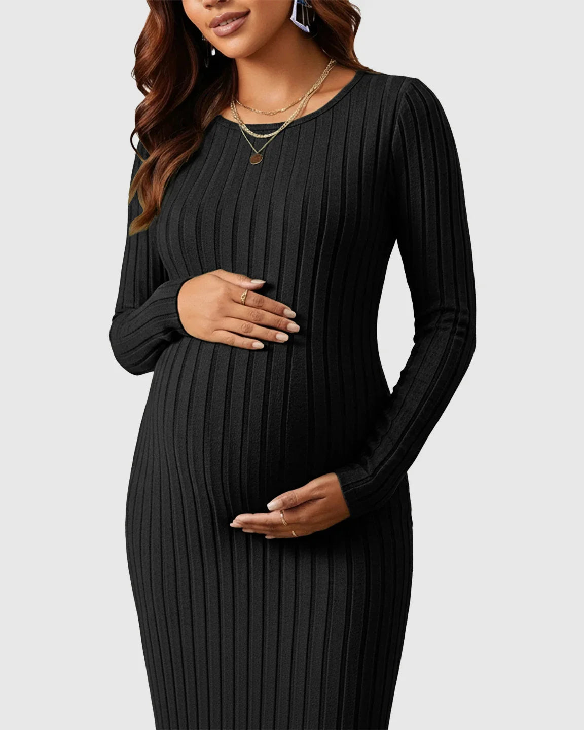 Pregnant woman in a black ribbed knit long-sleeve maternity maxi dress with a crew neck.