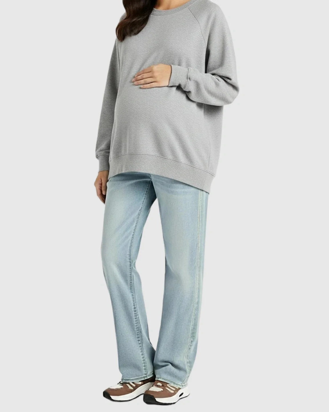 Pregnant woman in light wash, soft stretch straight-leg maternity jeans and a gray sweatshirt.