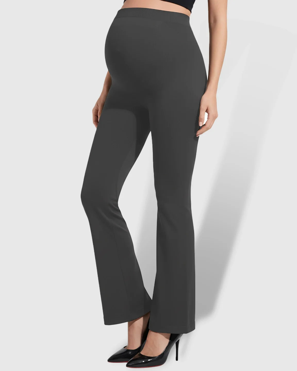 Dark gray over-belly bootcut maternity pants with a soft flare silhouette, worn by a pregnant model.