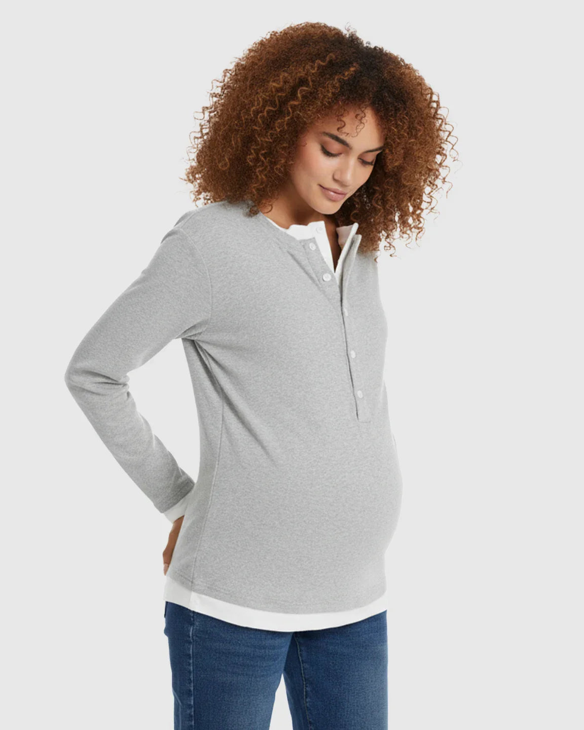 Pregnant woman in a gray long-sleeve button-front henley maternity and nursing top with a white underlayer.