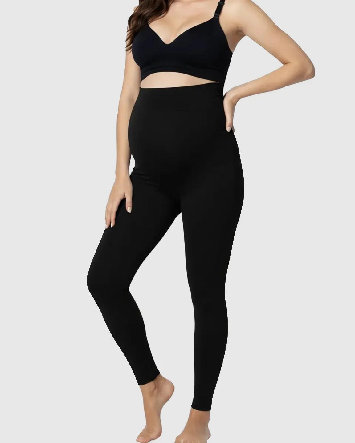 Pregnant model wearing black Bump Society Belly Support Stretch Maternity Leggings with a high waist panel.