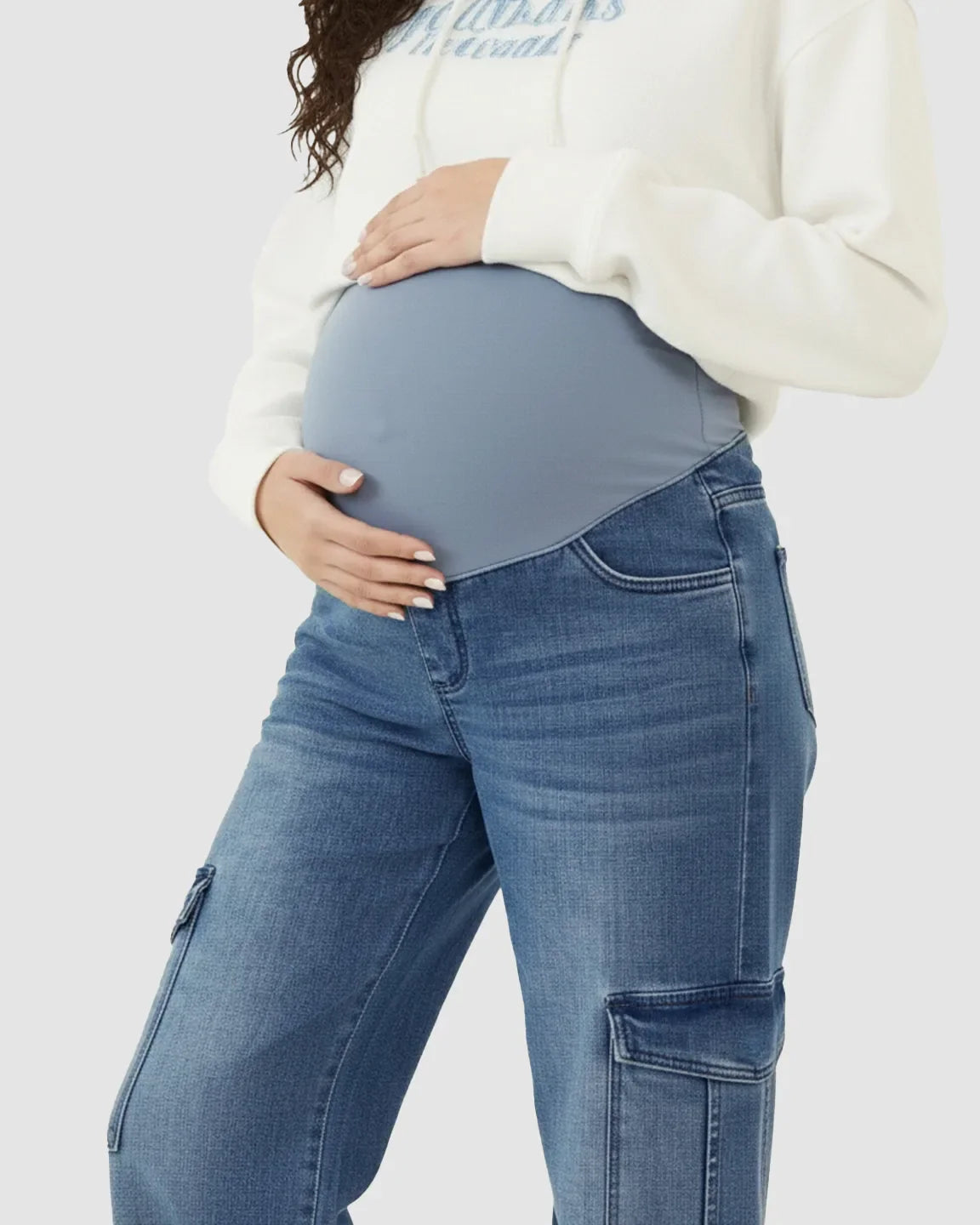 Maternity cargo jeans in a medium wash with a supportive blue over-bump panel and wide-leg fit.