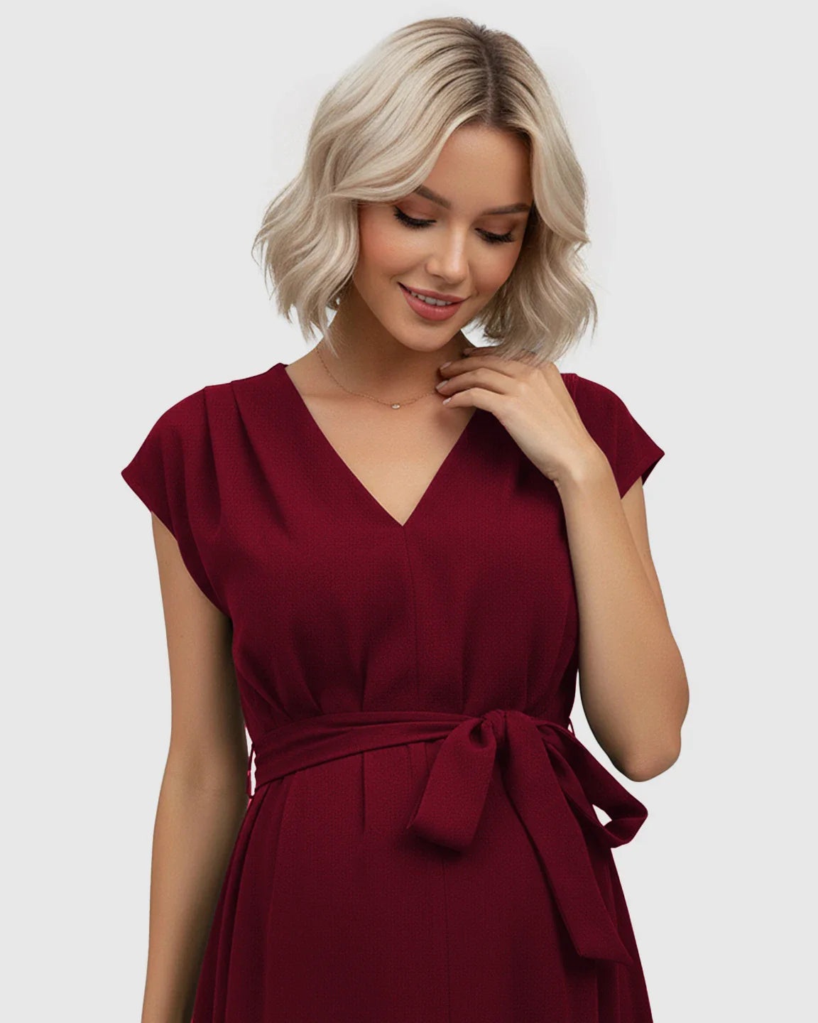 Blonde model in a red tie-waist V-neck maternity midi dress with flutter sleeves.
