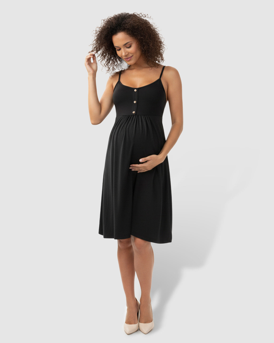 Black thin-strap A-line maternity midi dress with buttons, worn by a pregnant woman.