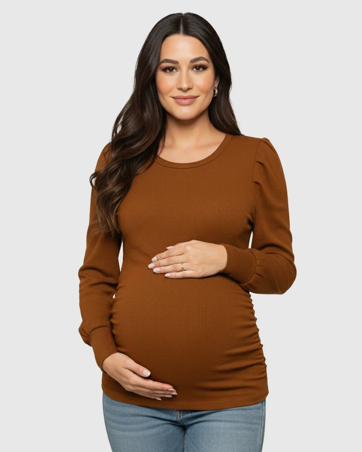 Pregnant woman in a warm brown, long-sleeve ruched maternity top with a round neck and side pleats.