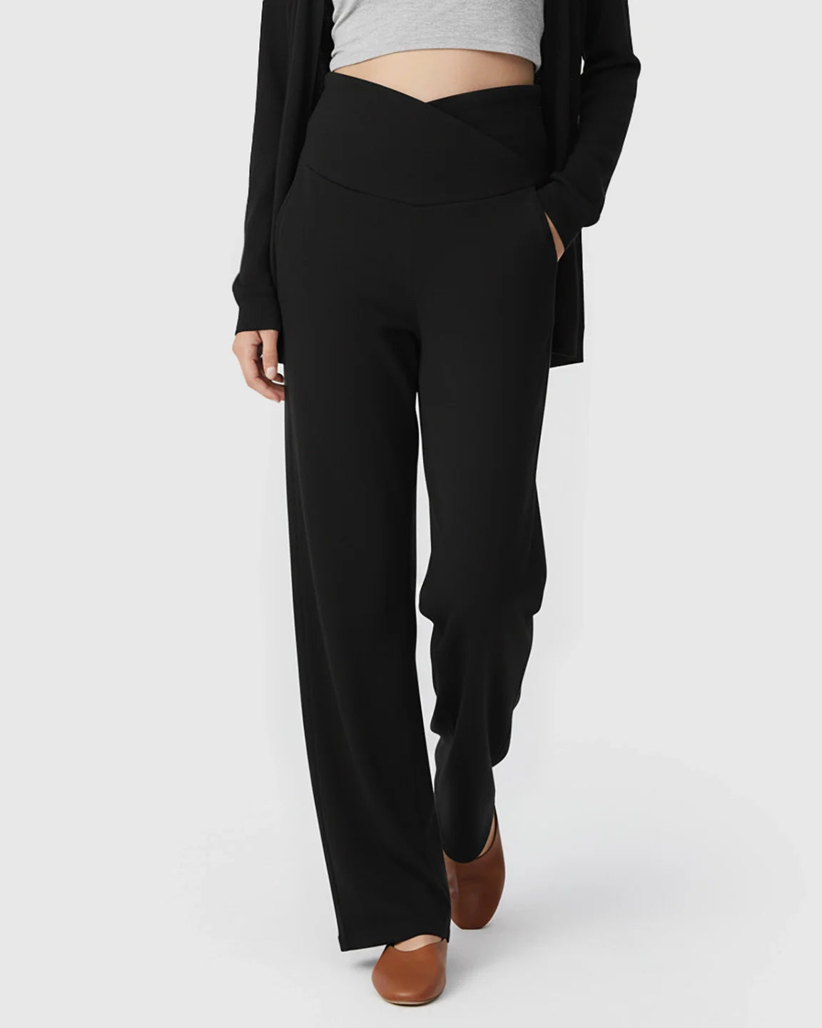 Black wide-leg maternity lounge pants with a crossover under-bump waist and deep side pockets.