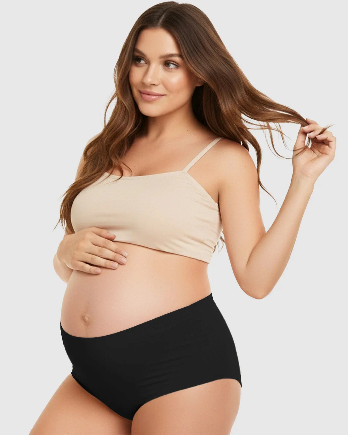 Smiling pregnant woman in a beige bra and black seamless high-waist support maternity underwear.