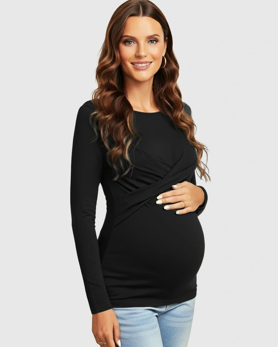 Smiling pregnant woman in a black cross-pleat fitted long sleeve maternity top with a round neckline.