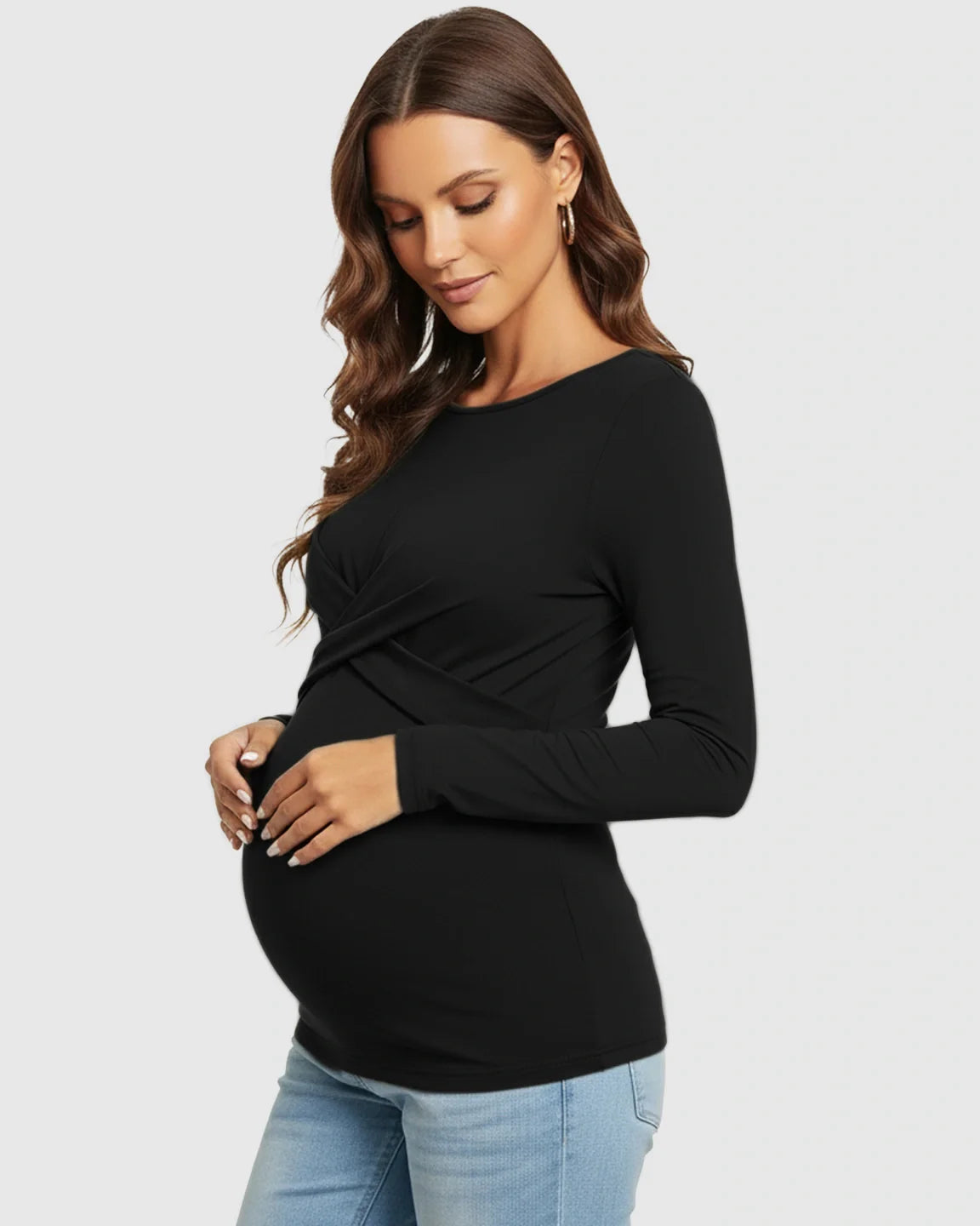 Pregnant woman in a black cross-pleat fitted long sleeve maternity top, highlighting her bump.