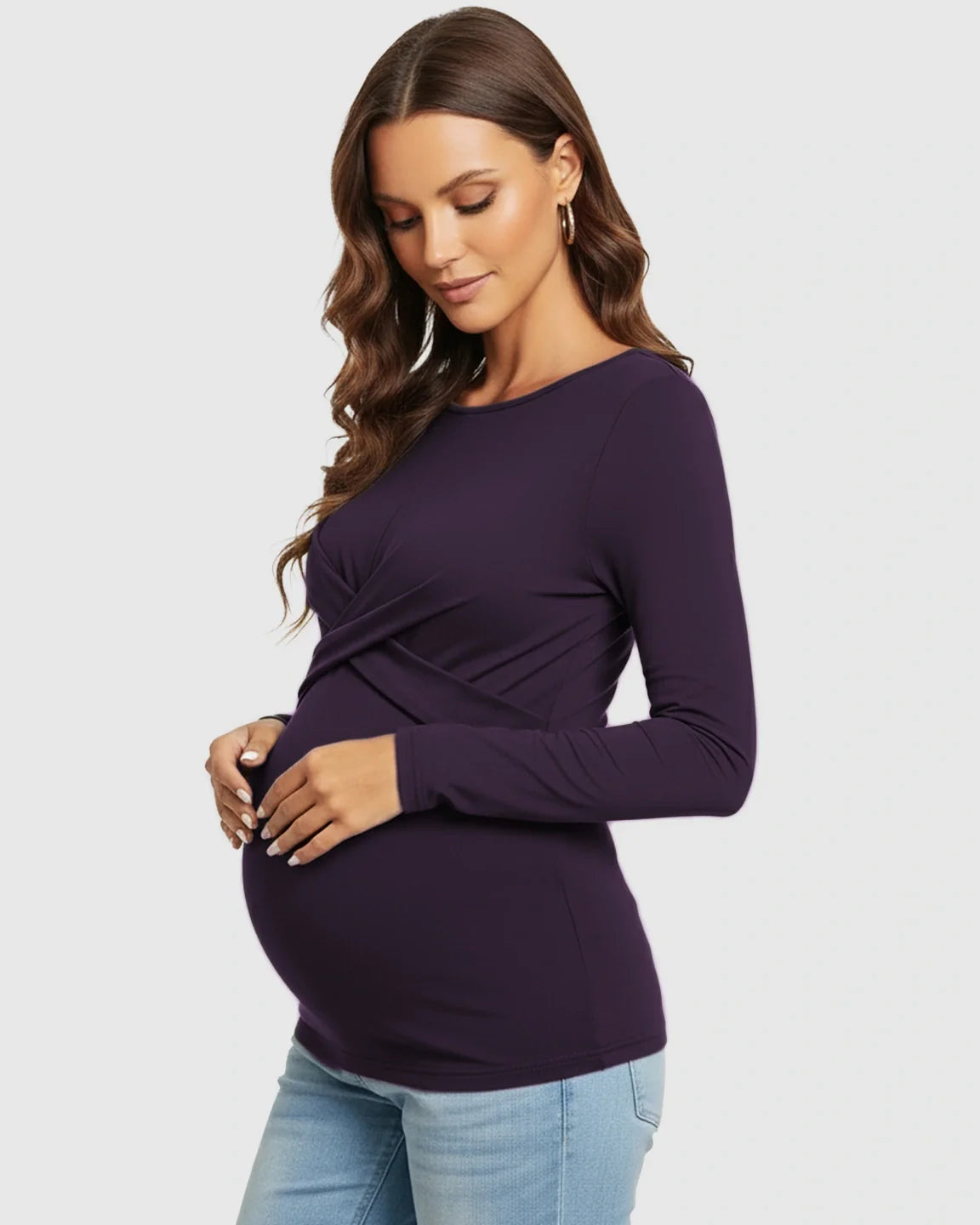 Maternity model in a dark purple cross-pleat fitted long sleeve top, highlighting her bump.