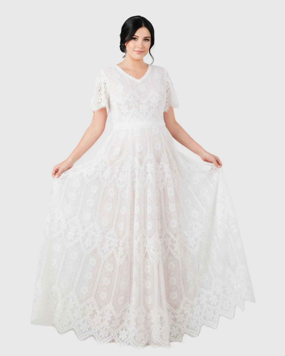 White vintage lace flutter-sleeve maternity gown with V-neck and long trailing hem.