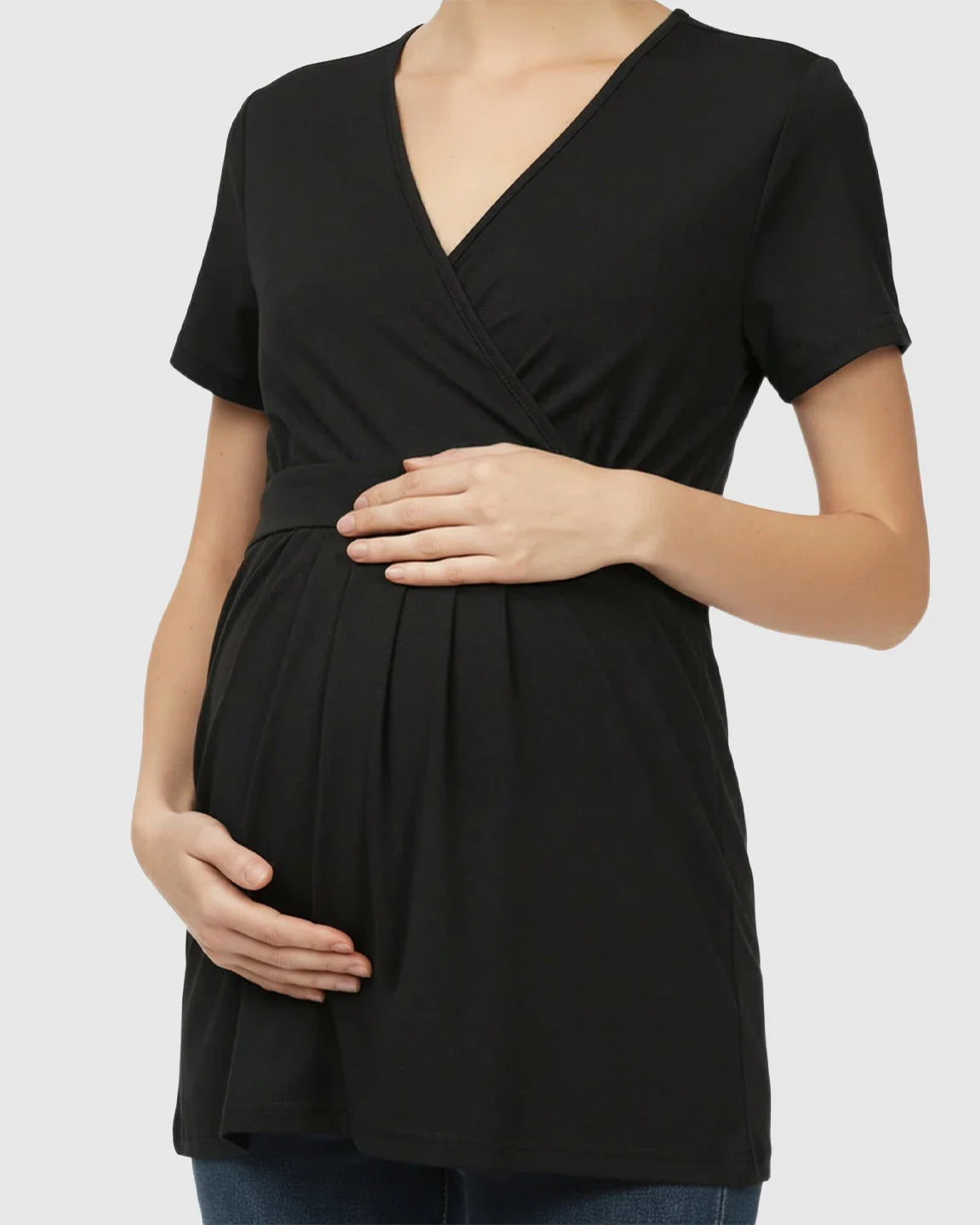 Black V-neck wrap-style maternity nursing top with short sleeves and an adjustable waist tie, worn by a pregnant woman.