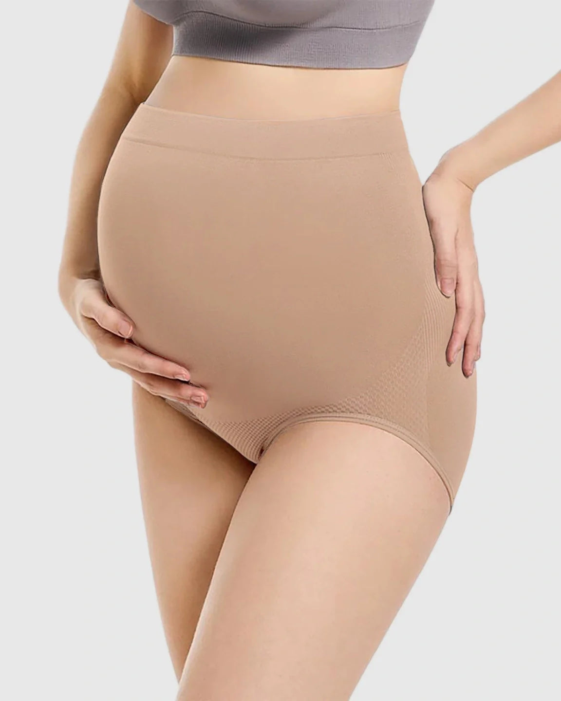 Nude seamless high-waist maternity panties on a pregnant woman, offering gentle bump support and comfort.