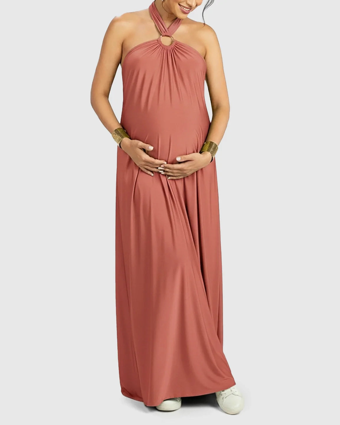 Maternity maxi dress in terracotta chiffon, featuring a backless halter neck and gold ring detail.