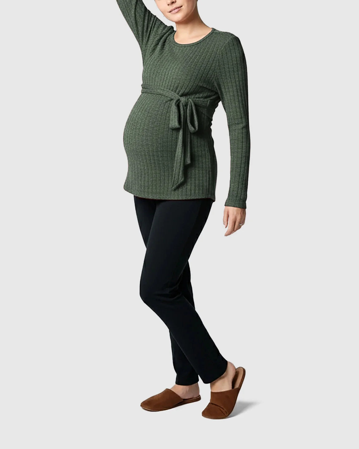 Pregnant woman in a ribbed olive green tie-waist long sleeve maternity sweater and black pants.