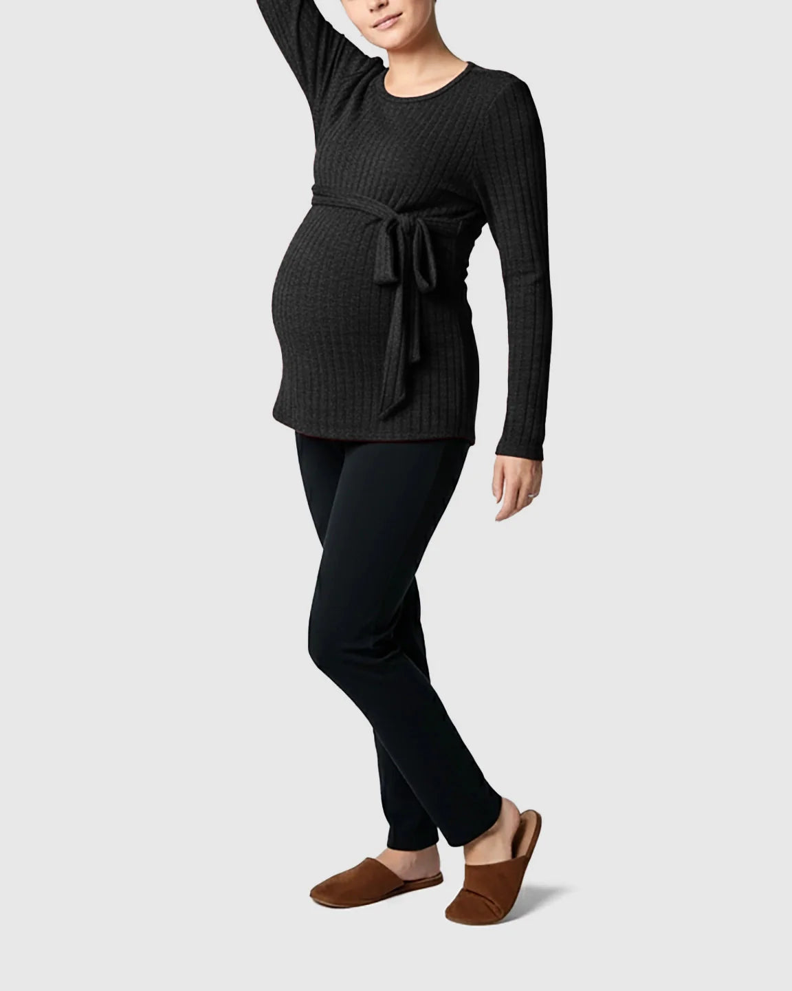 Pregnant woman in a charcoal ribbed tie-waist long sleeve maternity sweater and black pants.