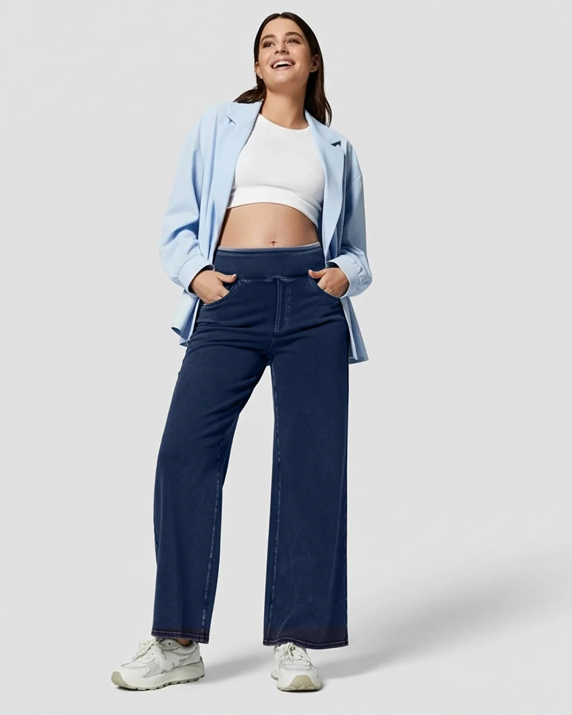 Smiling pregnant woman in high-waist, wide-leg navy maternity denim jeans with a soft waistband.