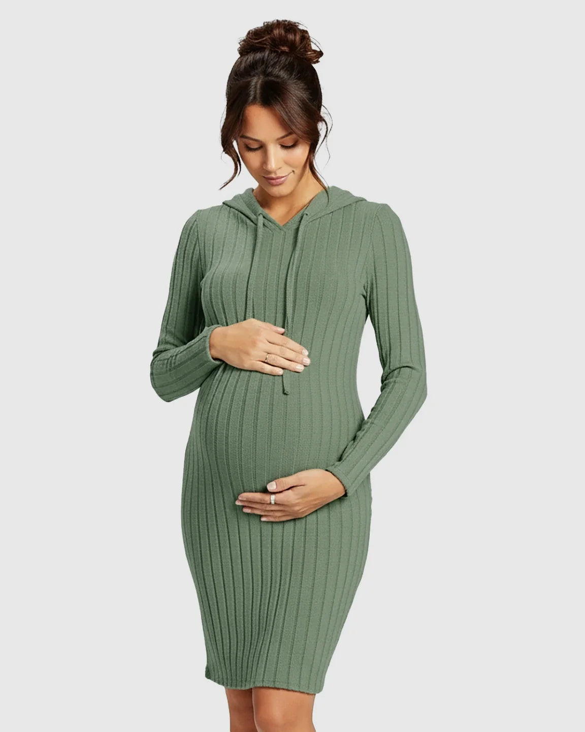 Pregnant woman in a sage green ribbed bodycon hooded maternity midi dress, gently holding her bump.