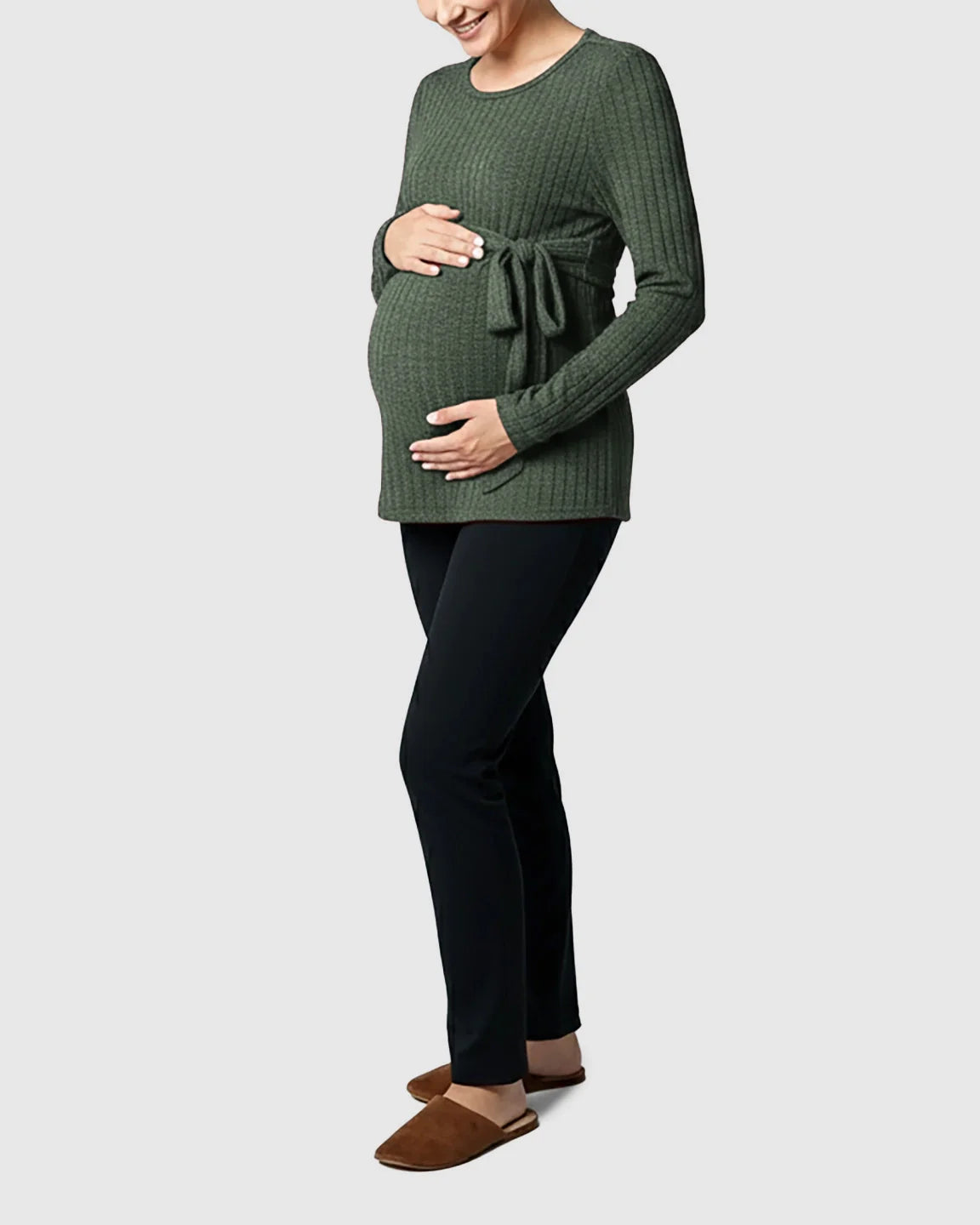 Pregnant woman in a green ribbed tie-waist long sleeve maternity sweater and black pants.