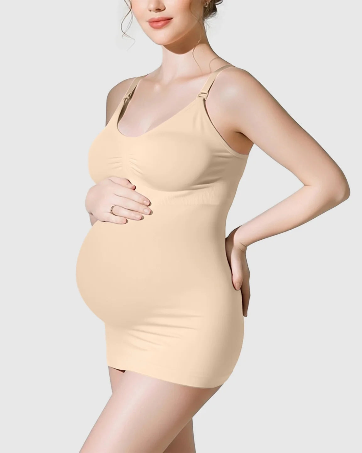 Pregnant woman wearing a nude soft stretch wireless maternity nursing camisole dress.