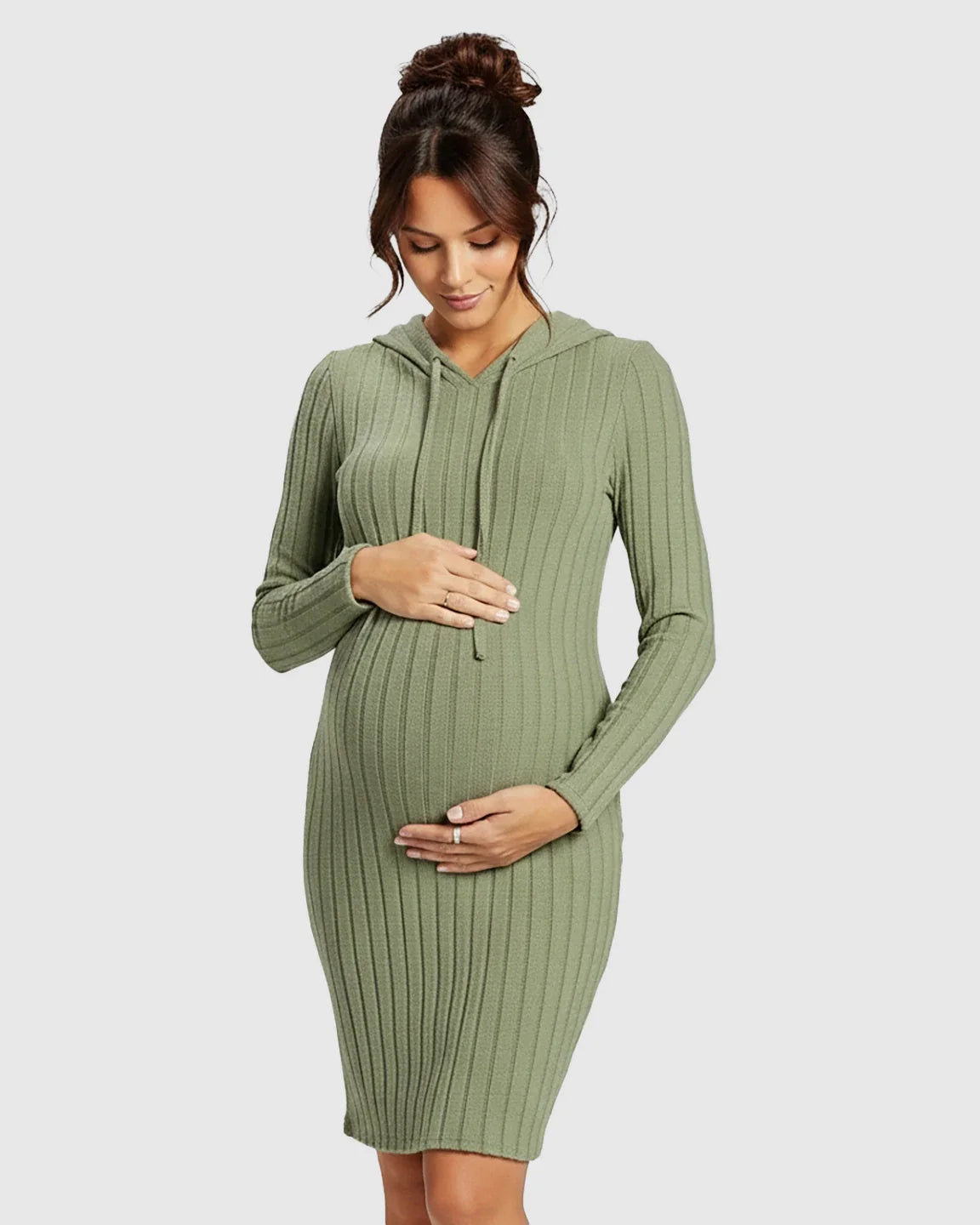 Pregnant woman in a sage green ribbed bodycon hooded maternity midi dress, gently holding her bump.