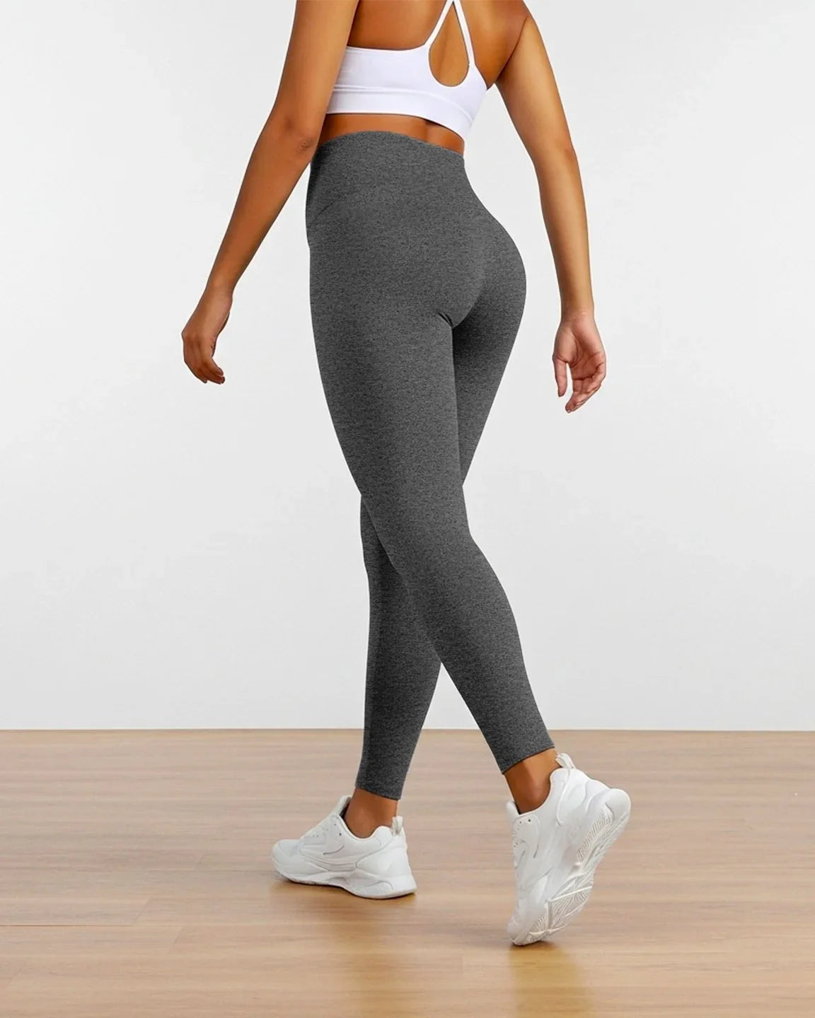 Woman modeling dark gray sculpting ankle-length maternity leggings with a high waist.